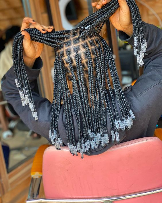 Check out that crystal bead cascade on a bed of knotless black silk. Sounds luxurious, right?: knotless braid styles with beads,  small knotless braids,  protective hairstyle,  knotless box braids,  luggage and bags,  Box braids,  Black hair  